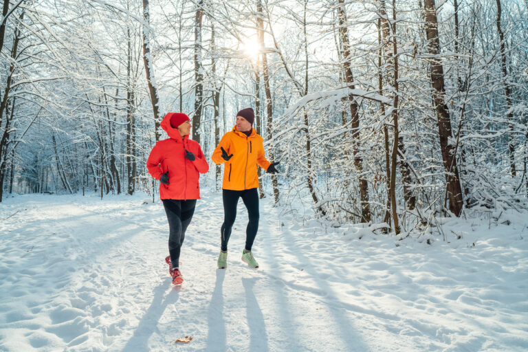 mann og kvinne som er på joggetur sammen i snøen